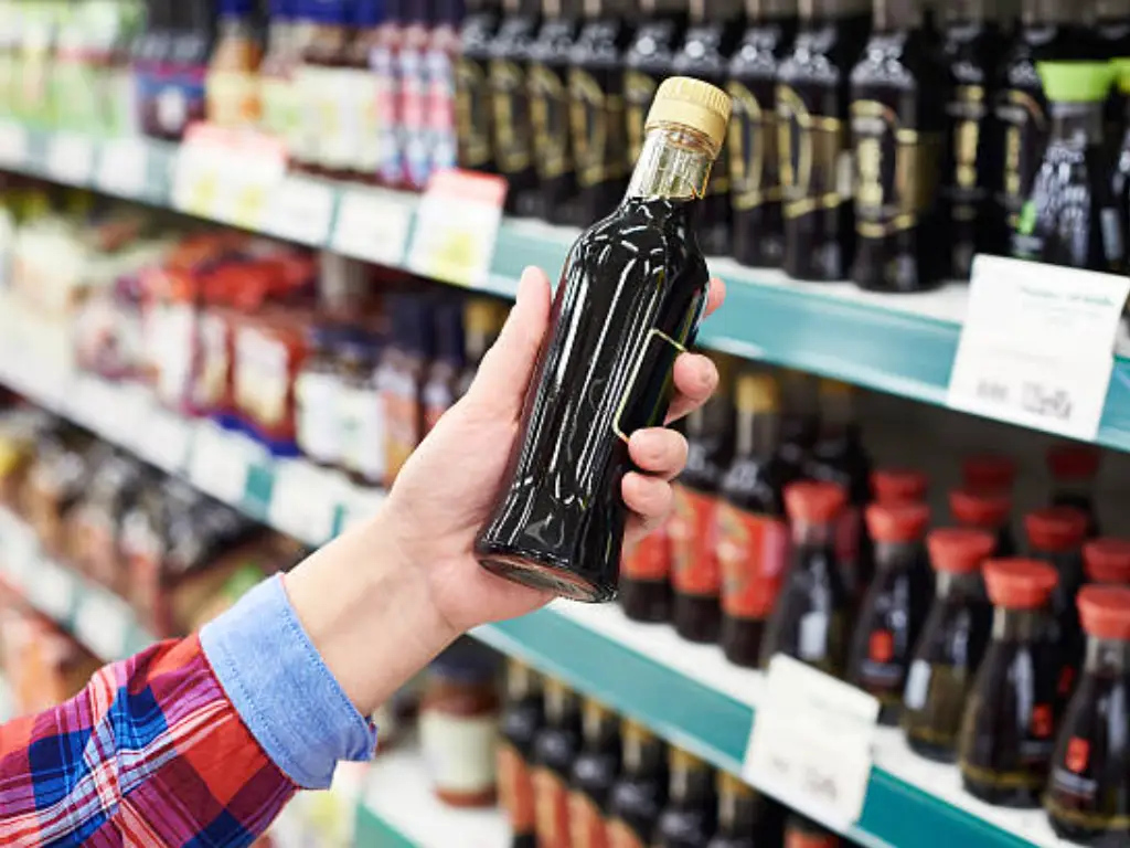 people select the soy sauce in the supermarket